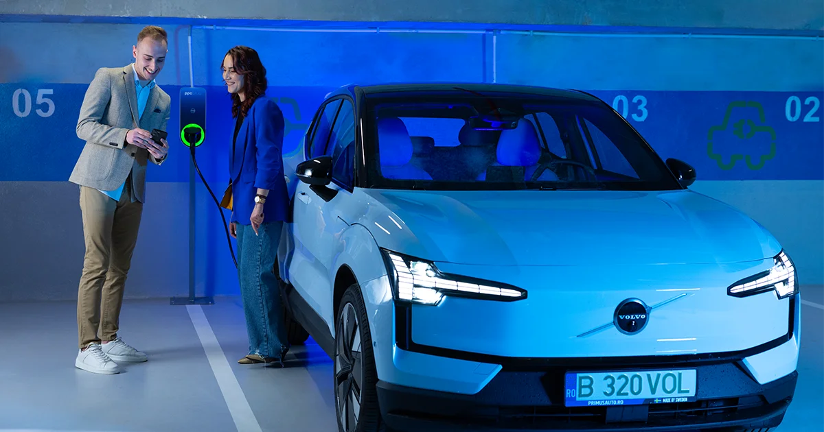 Femeie și bărbat lângă o mașină electrică la stația de încărcare PPC blue